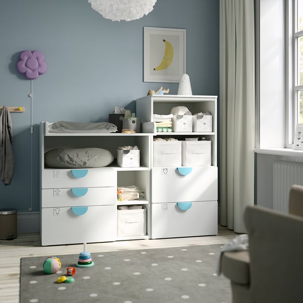 Kids room with SMÅSTAD storage, changing table, toys, and bright window.