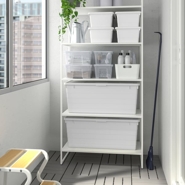 White SOCKERBIT shelf with boxes, cleaning supplies, plant, under window.