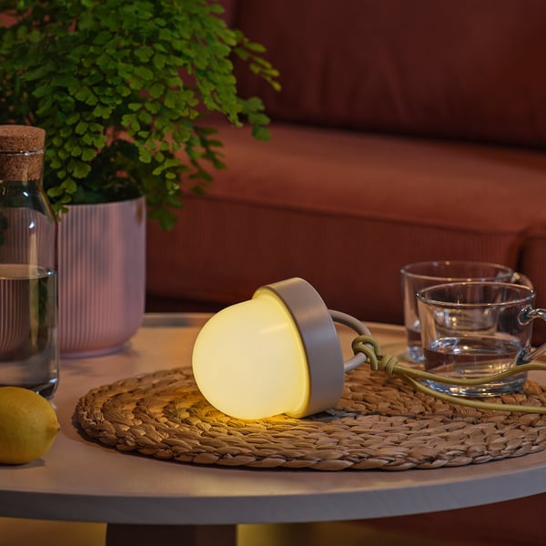 Solar lamp on table, teacups, lemon. Lights up in dark.