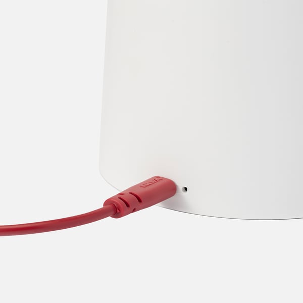 Close-up of a red usb cable plugged into a sleek, white lamp. The high-quality design and modern aesthetics of the SPANNLAND lamp.