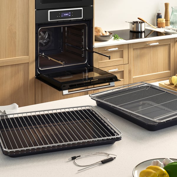 Modern kitchen with STENABY oven showcasing air fry trays, highlighting its versatile cooking options and crispy results.