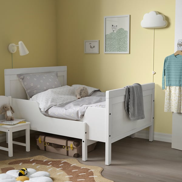 Kids room with SUNDVIK bed, yellow walls, lamp, toy, and rug