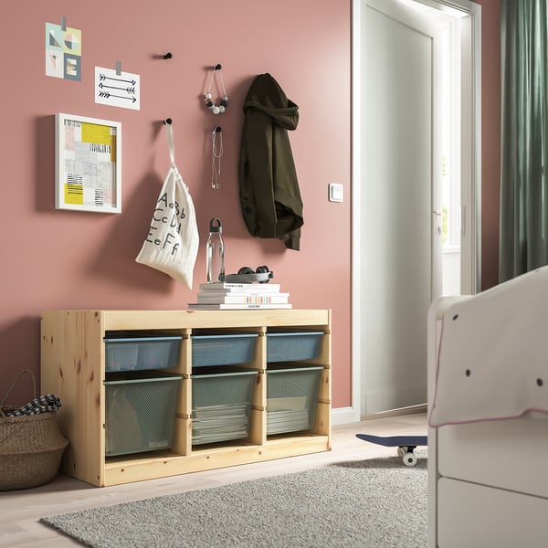 Pink teen bedroom with TROFAST pine & mesh storage, coat, bag, sunglasses, skateboard.