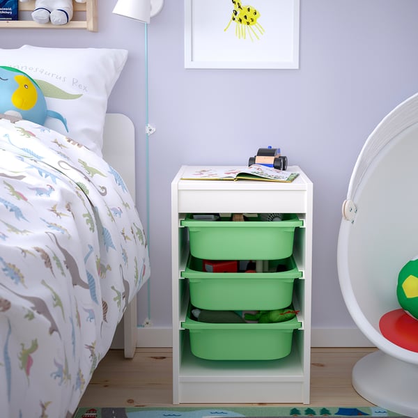 Childs room with white TROFAST storage unit. Bins hold toys, near dinosaur-themed bed.