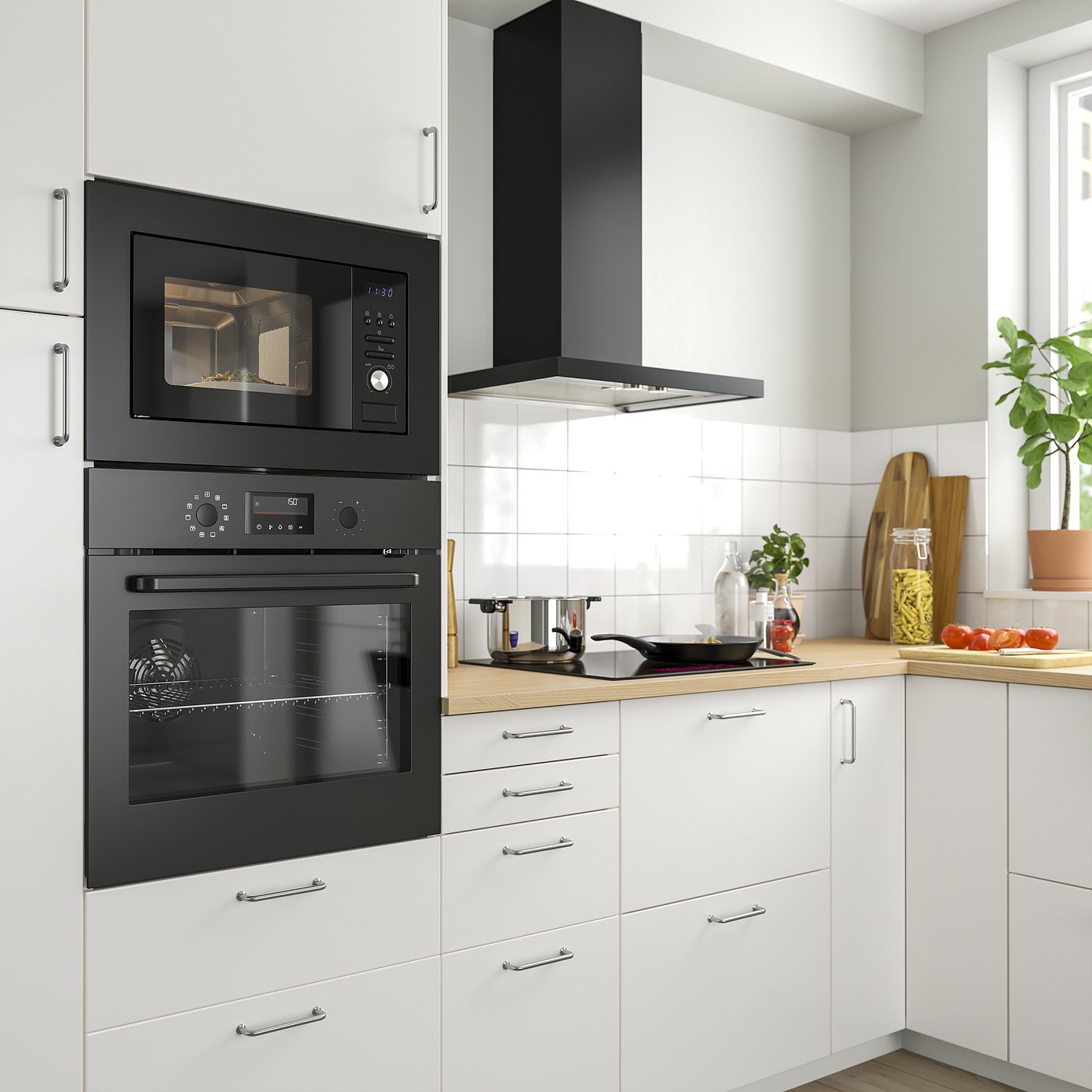 Modern kitchen with built-in black VÄRMD microwave and oven combo, white cabinets, wooden countertop, and a black range hood.