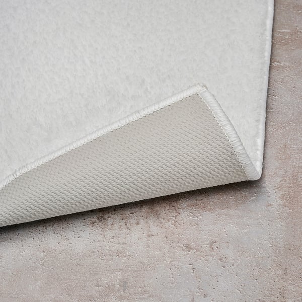 White bath mat corner with latex backing, soft and thick.