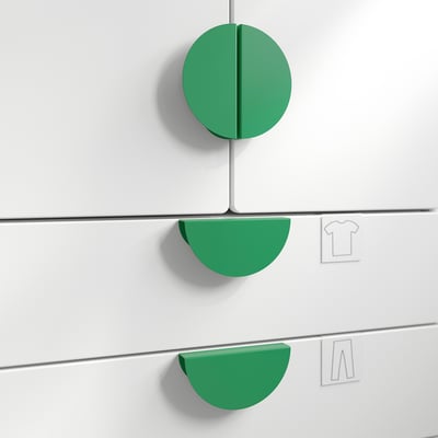 Three green circular knobs on white drawers, perfect for gripping and adding colour.