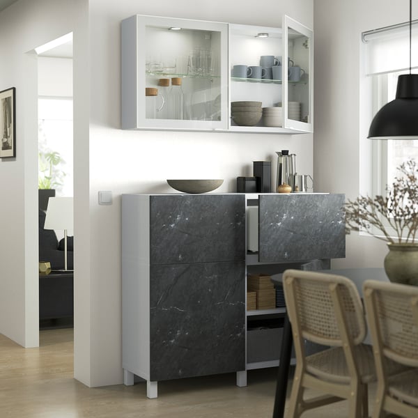 Modern kitchen with dark marble cabinet, glass doors, and sleek metal legs.