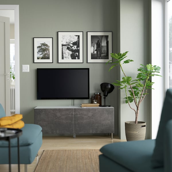 Modern living room with BESTÅ tv bench, turquoise chairs, plant, and wall art.