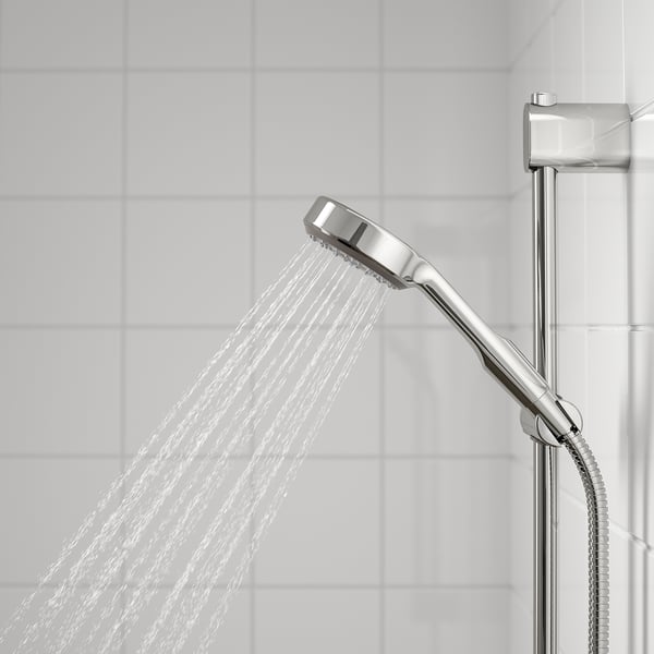 Chrome handshower with full spray function on riser rail, water flowing down.