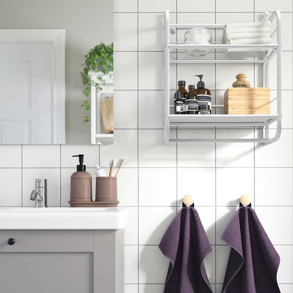 White bathroom with FRÖSJÖN wall shelf, towels, and toiletries.