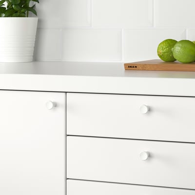 Kitchen drawer with GUBBARP knobs, limes, green plant.