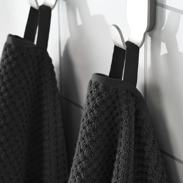 Two black towels hang neatly on hooks; one soft and fluffy, ideal for everyday use.