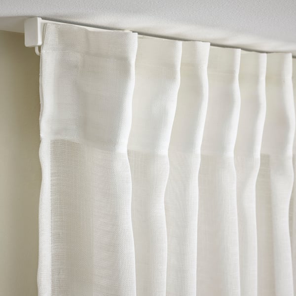 Curtain close-up showing sheer fabric with pleats and heading tape for easy hanging.