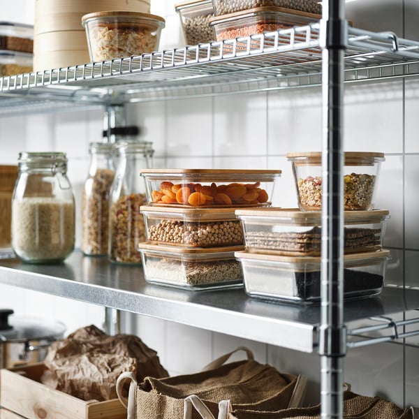 Metal shelf with glass jars and clear containers storing dried foods, showcasing organised pantry storage.