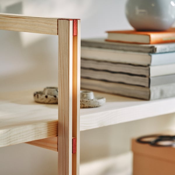 Natural wooden shelf with red-painted corner details, showcasing modern minimalist design.