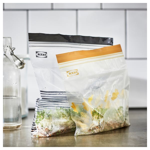 Stacked ISTAD reusable food storage bags on a countertop with visible contents.