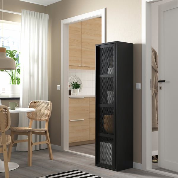 IVAR black metal cabinet in modern living space, near kitchen and dining area with wicker chairs. Sleek, functional, and contemporary.