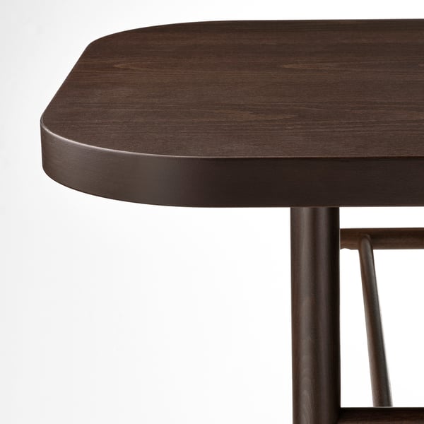 Close-up of a dark wood table with sleek, curved edges and robust metal legs, illustrating high-quality craftsmanship and durable design.