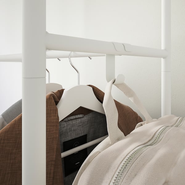 Closet with hangers holding coats and hooks for accessories.