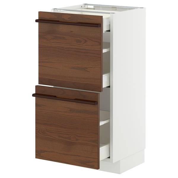 Modern kitchen cabinet with dark brown wood drawers, white sides, and sleek handles; part of the ikea METOD system.
