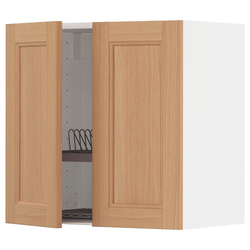 A light brown wooden cabinet with one door open, revealing a white interior with a metal dish drainer.