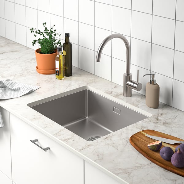 Modern kitchen with MÖCKLARP sink, marble counter, potted plant, soap dispenser, cutting board, and knives.