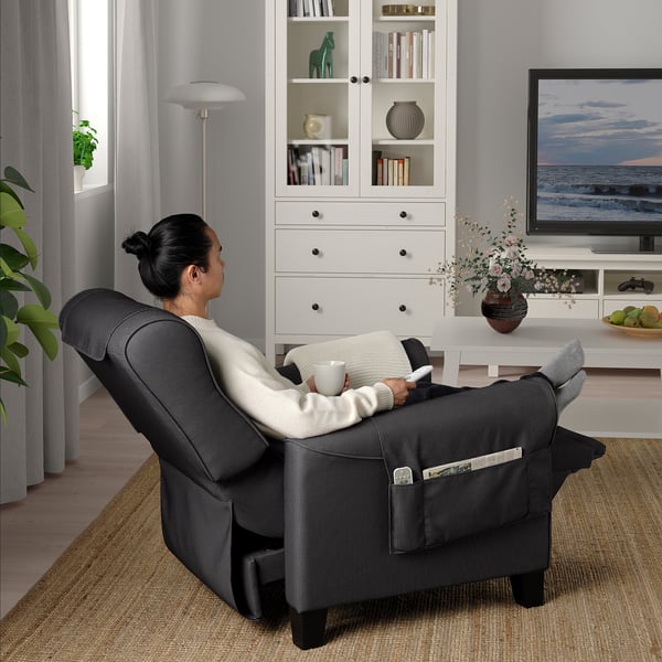 Person relaxing in a MUREN recliner, holding a cup, with a tv showing a beach scene.