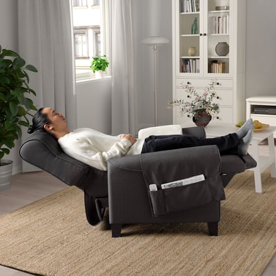 Person relaxes in adjustable MUREN recliner with footstool in cosy living room.