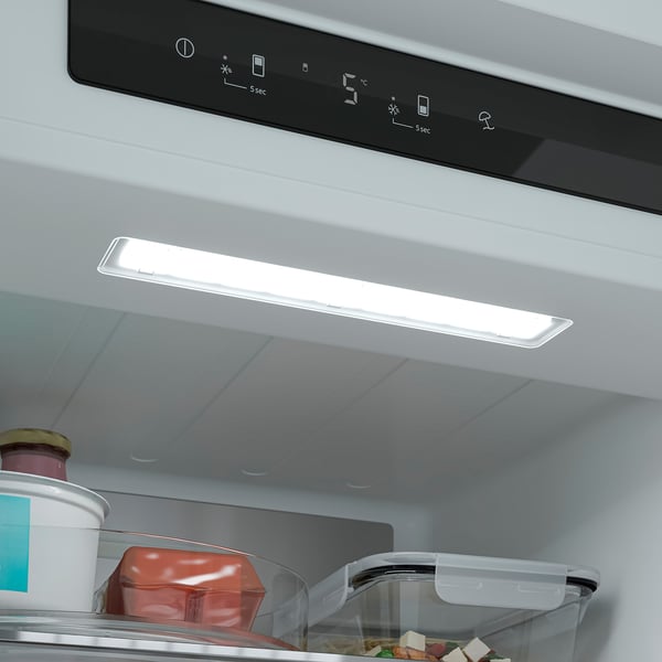 Image shows an open refrigerator with led lighting on and adjustable shelves visible.