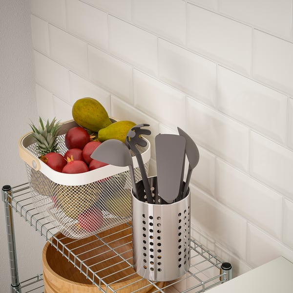 Kitchen cart holds fruit and utensils on metal shelves, keeping items visible and secure.