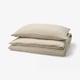 Three folded beige bed linens, made of soft cotton, stacked neatly.