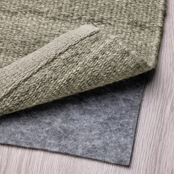 A grey wool rug with a non-slip underlay, ideal for comfort and stability on various flooring types.