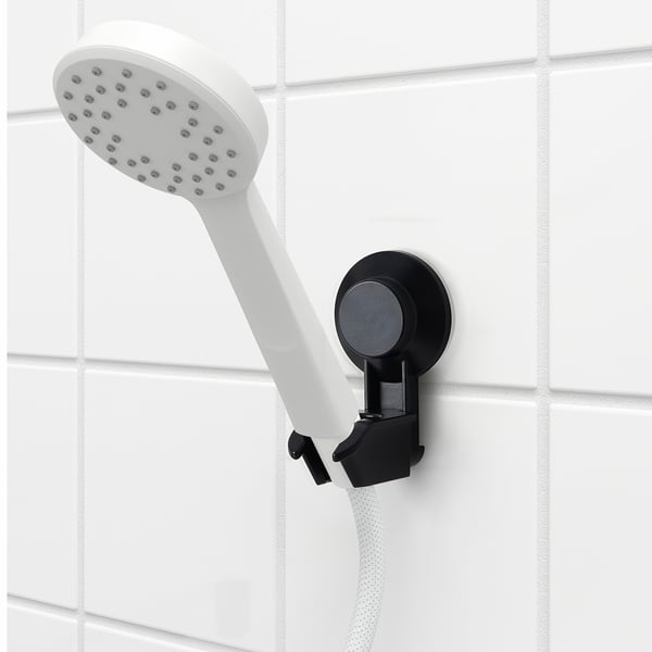 TISKEN white handheld shower head with black suction cup bracket. Adjustable and compact.