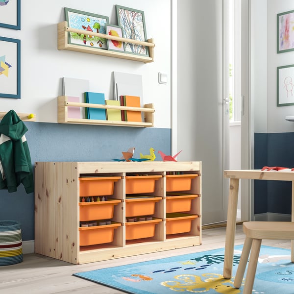 Kids room with TROFAST light wood storage, orange containers, shelves, colourful rug, and art.