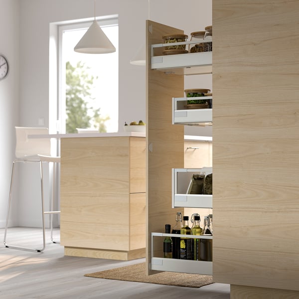 Modern kitchen with wooden cabinets; pull-out storage solution holds bottles, jars, and containers, optimising space and visibility.