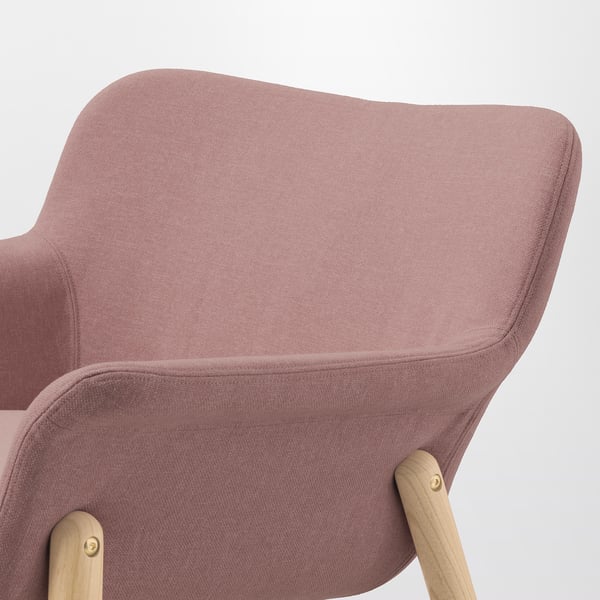 Close-up of a pink upholstered chair with wooden legs, showcasing its sleek design and high-quality fabric.