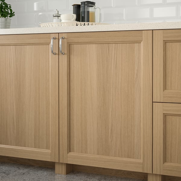 Wooden kitchen cabinets with metal handles and countertop items.