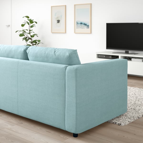 Modern blue VIMLE sofa in minimalist living room with tv, plant, and art.