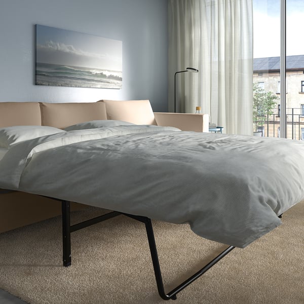 Modern bedroom with VIMLE sofa-bed and grey bedding, large window, sheer curtains.