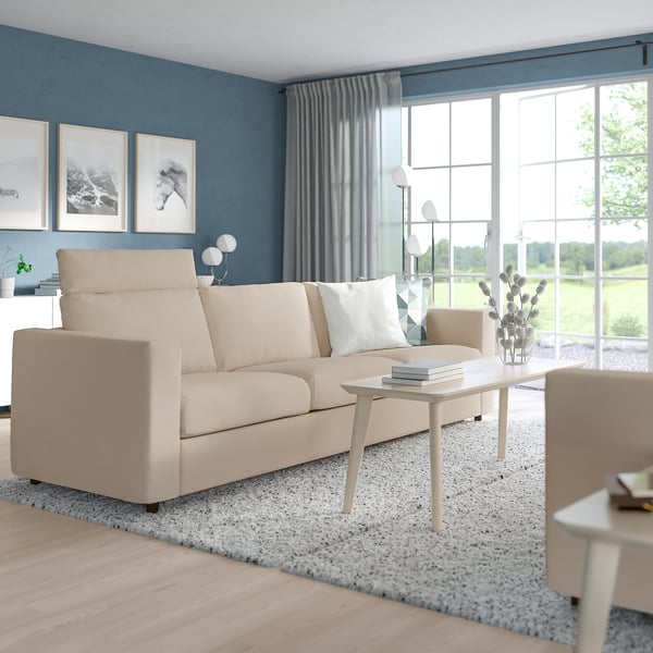 Modern living room with VIMLE sofa, large windows, blue walls, grey curtains, and small table.