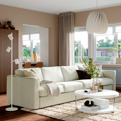 Cosy living room with VIMLE off-white sofa, rug, coffee table, pendant light, and window.