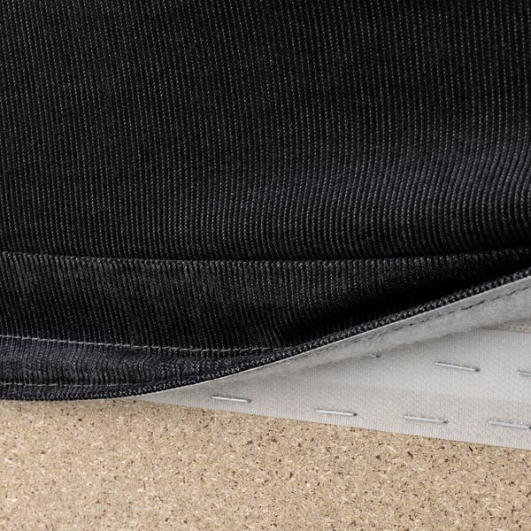 Black sofa fabric with visible stitching and zip, showcasing removable cover for easy cleaning.