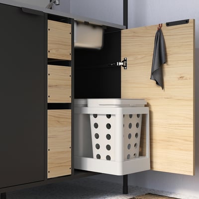 Kitchen cabinet with open storage, including organised laundry basket and hooks.