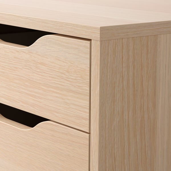 Light wooden drawer unit with sleek, cut-out handles; well-crafted and organised.
