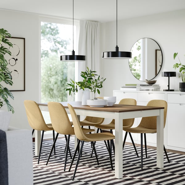 Modern dining set, ÅLHULT table, beige chairs, black pendants. Large window, curtains, plants, mirror, striped rug. Extends for 6-8.