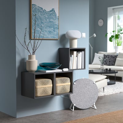 Blue living room with dark shelf, lamp, air monitor, and artwork.