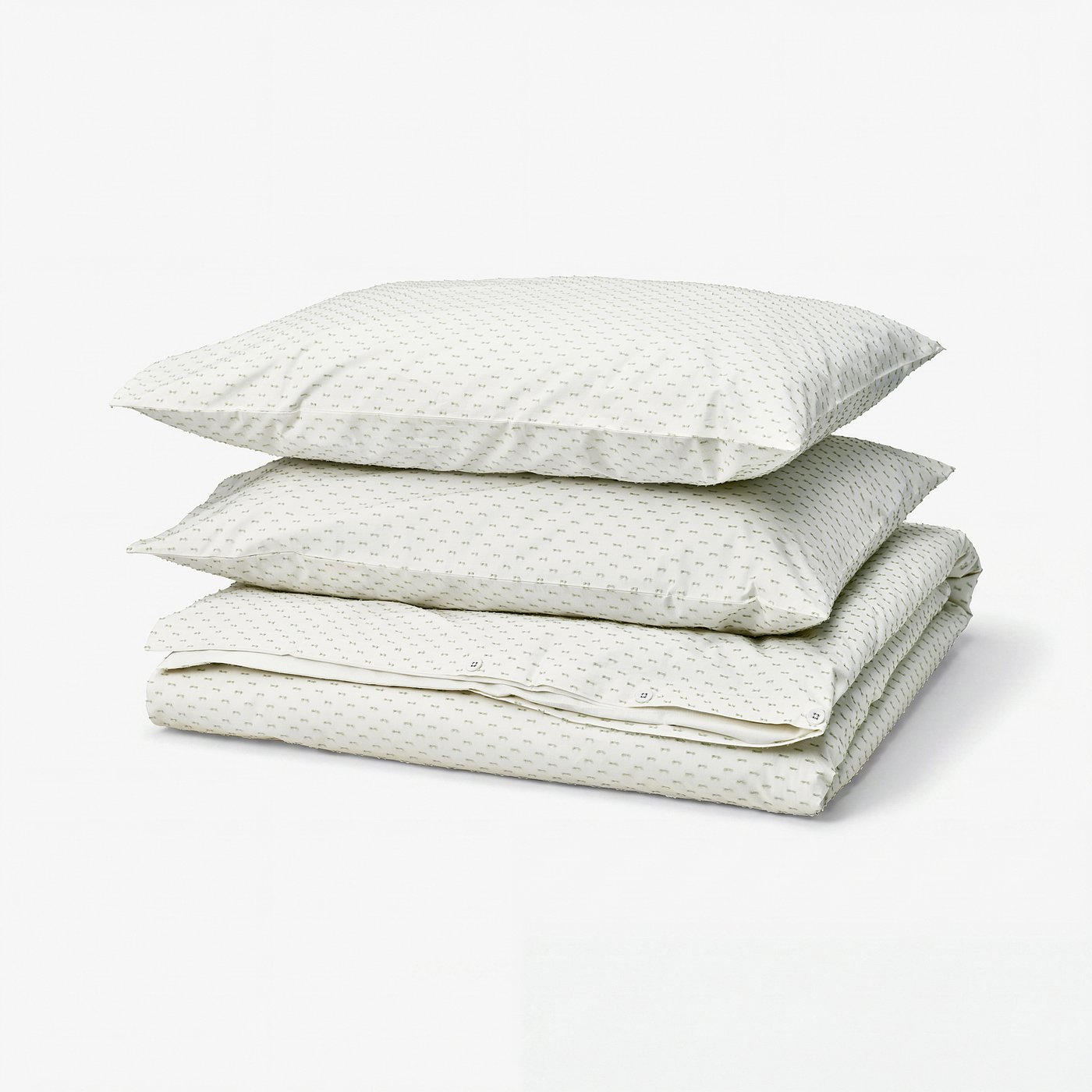 A stack of three white BANDKNIPPE cotton duvet covers with green polka dots, neatly folded.