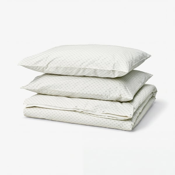 A stack of three light green, white dotted BANDKNIPPE cotton duvet covers against a white background.