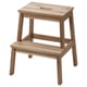 A BEKVÄM wooden step stool in natural colour, with a rectangular seat and four angled legs. Its made from acacia wood and has a simple, sturdy design.